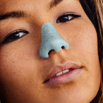 Load image into Gallery viewer, close up of girl wearing Nöz sunscreen in blue 
